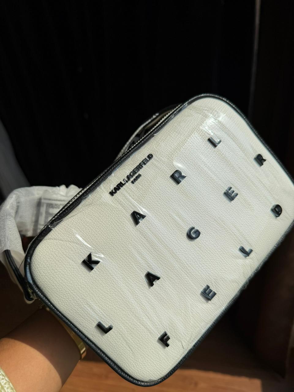 Karl Lagerfeld Paris Maybelle Camera Crossbody bag in white with black lettering.